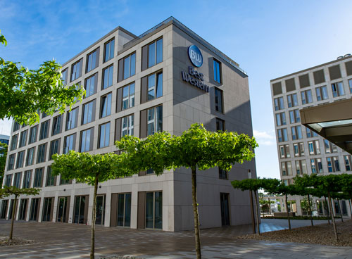 Modernes Best Western Hotelgebäude bei Tag, mit Bäumen im Vordergrund.